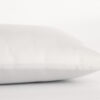 Child's wool pillow in white cotton encasement against plain background