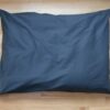 Shepherd's Dream EcoWool Pet Bed with blue cover on hardwood floor.