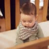 Baby sitting on an organic crib mattress