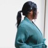 Woman standing in a bathroom window with cotton robe