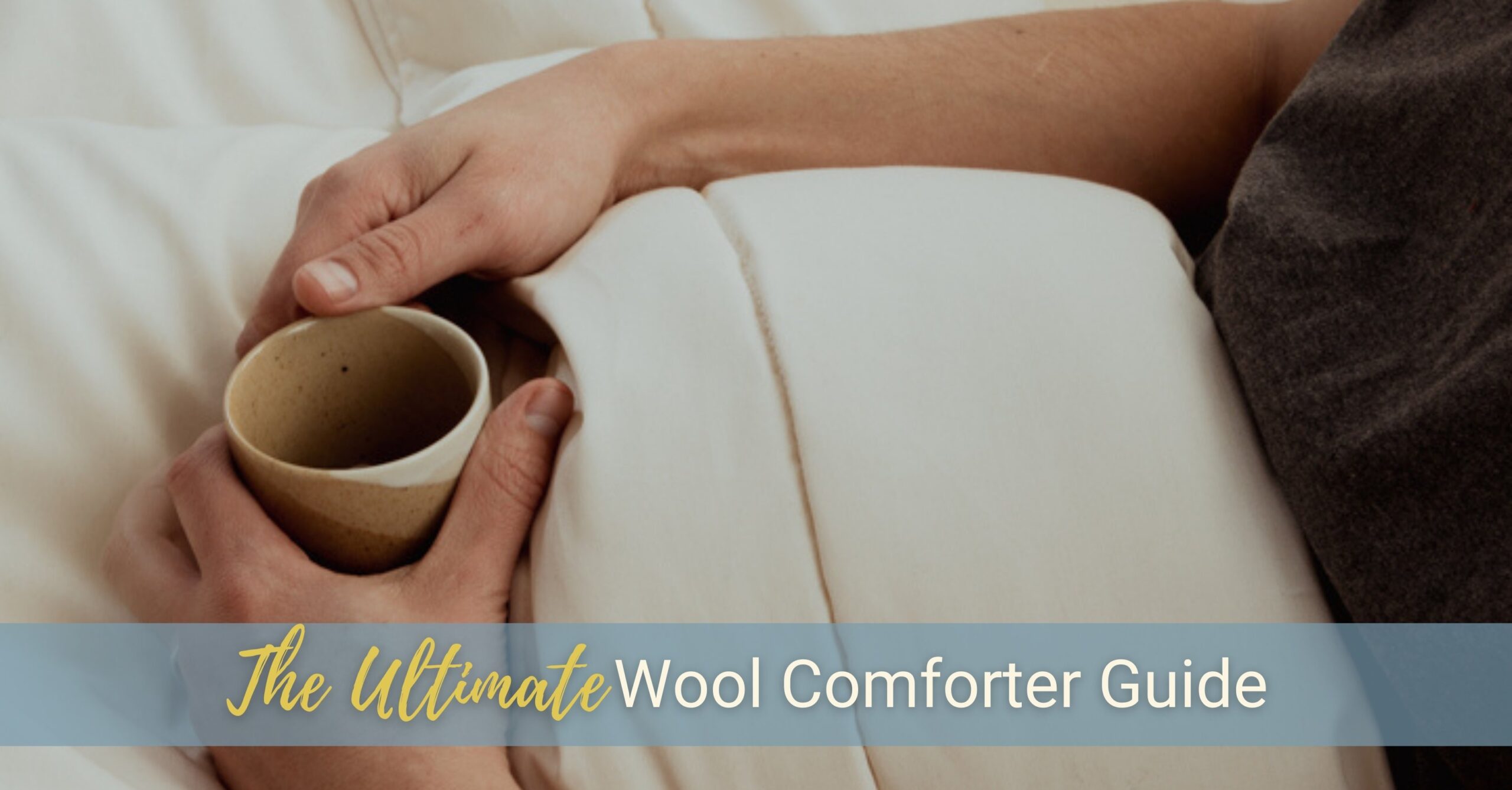 We see someone's arms resting on their wool comforter while in bed, relaxing with a cup of coffee.