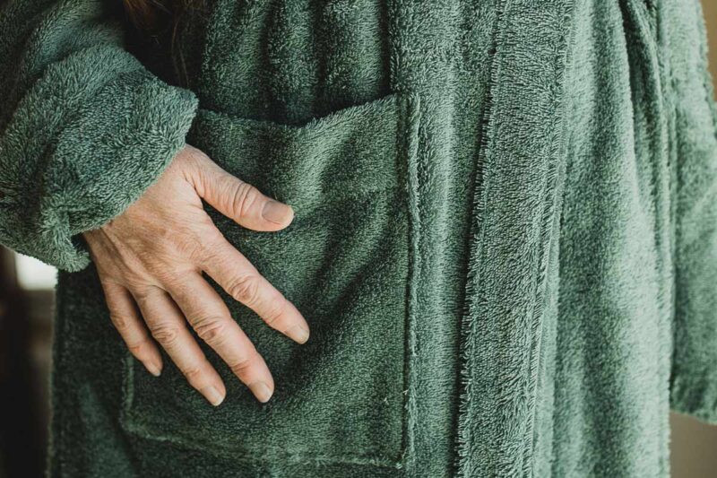 Hand placed on green cotton terry robe