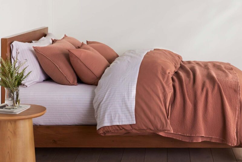 Organic bedroom with sedona reddish brown sheets and duvet
