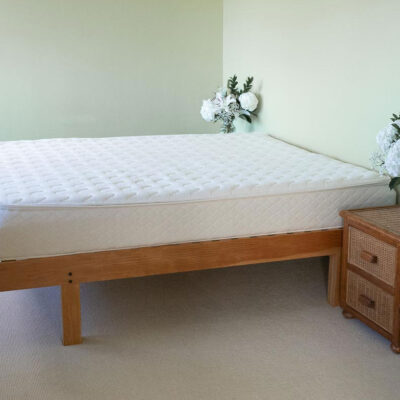 Side view of mattress with nightstands and floral arrangements.