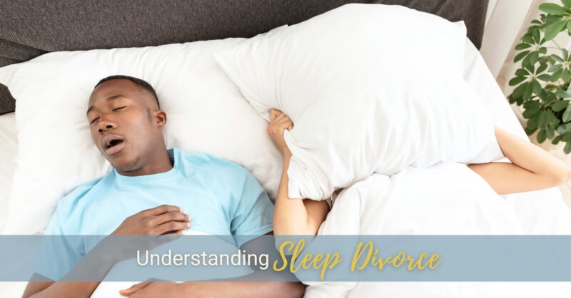 A couple sleeps in bed. The man is snoring, while his partner is hiding under a pillow.
