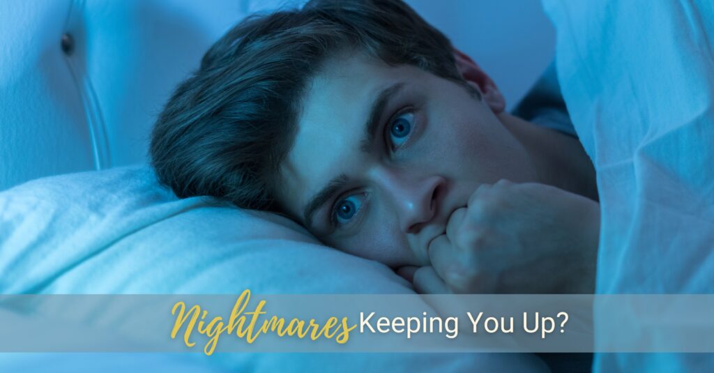 A young man lies awake in the middle of the night with eyes wide open after waking up from a nightmare.