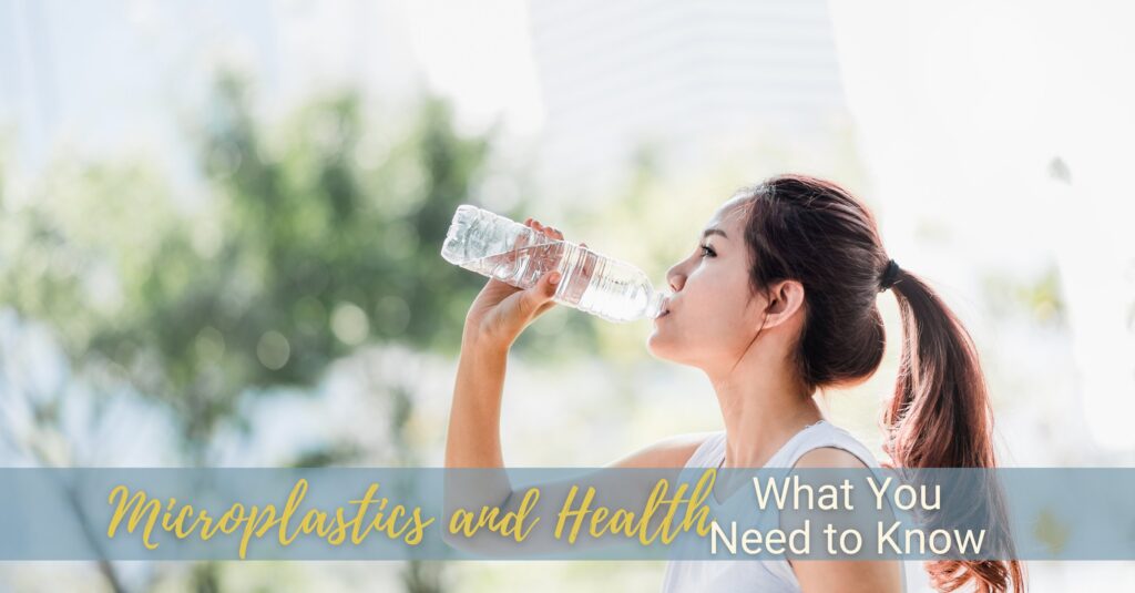 A young woman drinks water from a plastic bottle.