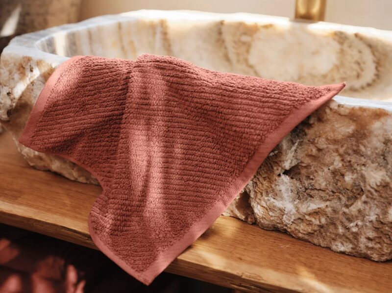 Coyuchi organic cotton Air Weight washcloth in Sedona on a pedestal marble sink