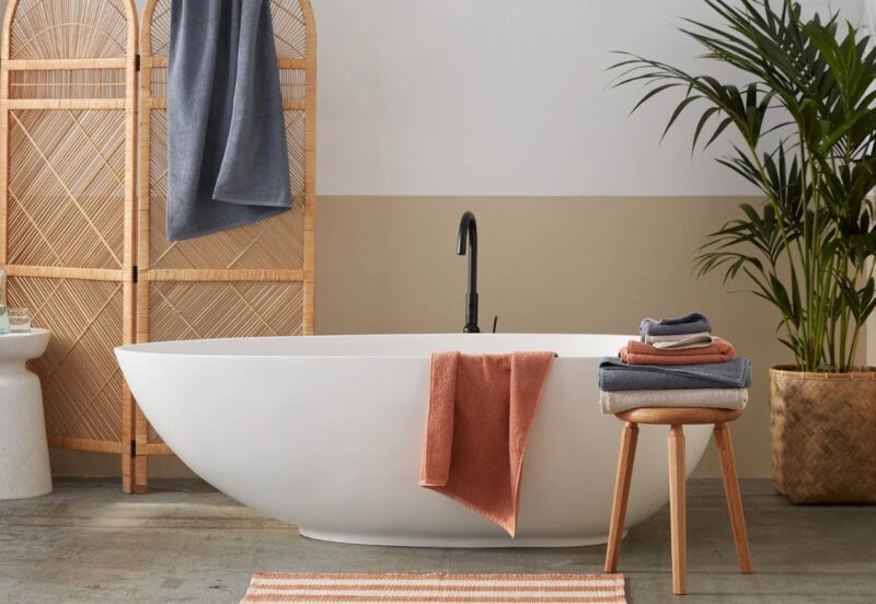 Bathroom with Coyuchi organic cotton Air Weight towels in Sedona and Gulf on a white bath tub