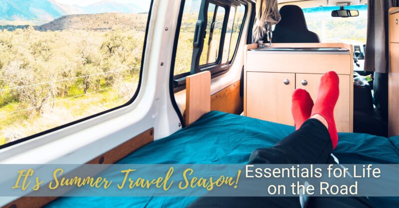 A person lounging wearing red socks looks out the window of their camper van over a desert landscape.