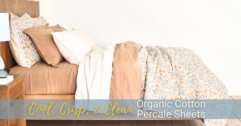 A lovely well-made bed featuring a patterned quilt and organic cotton percale sheets.