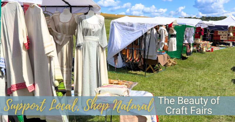 Artisan booths displaying cotton dresses are set up outside on a beautiful sunny day.