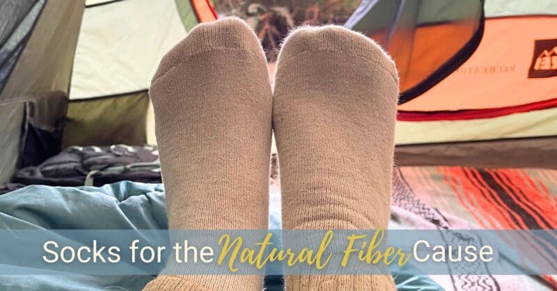 Organic Threads Fox Fibre Socks adorn a pair of feet looking out of a camping tent.