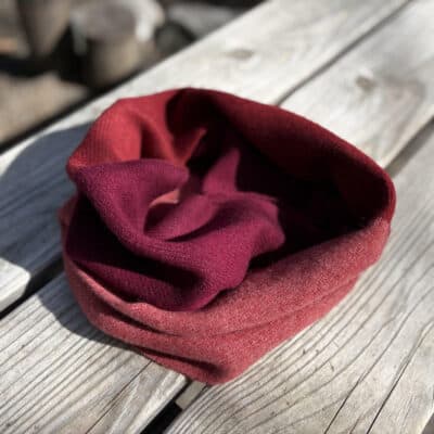 red lambswool infinity scarf on a wood bench
