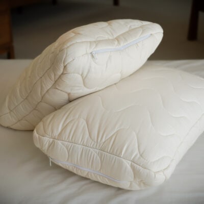 Adjustable latex cube pillow on a white bed